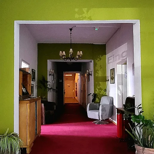 Der Eingangsbereich des Sanderhauses mit Blick entlang des Flurs. Es sind verschiedene Möbel zu sehen
